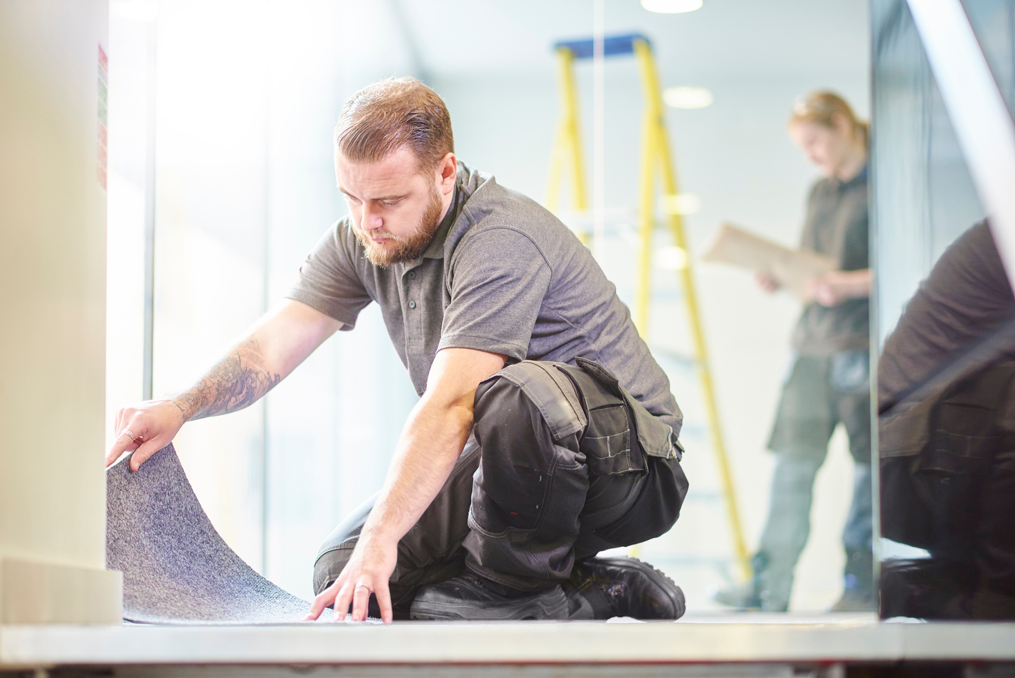 male carpet fitter fitting office carpet tiles